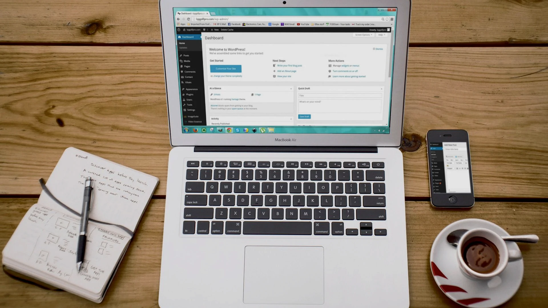 Marketing workstation with laptop dashboard, smartphone, and notebook for structured campaign planning