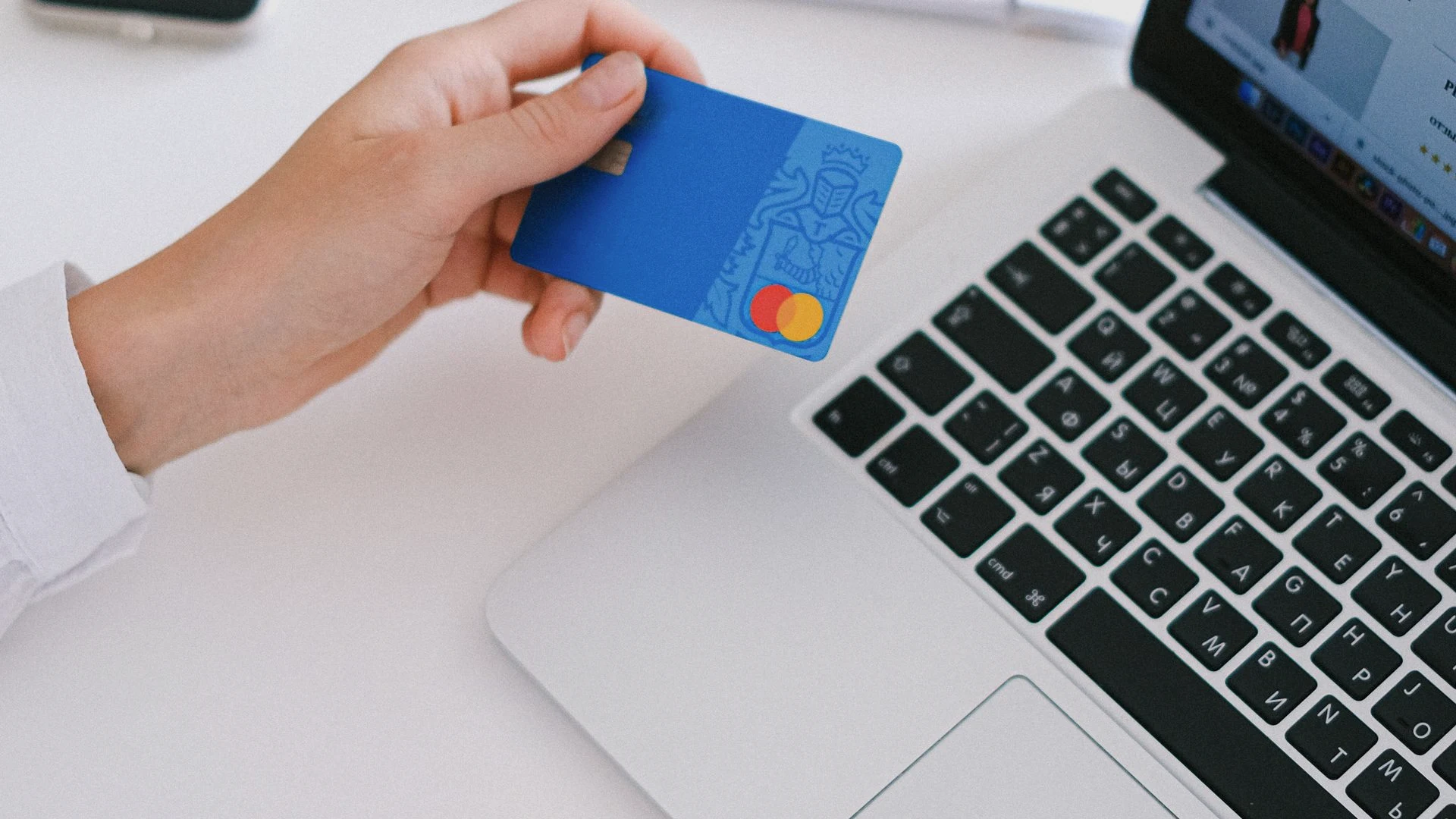Customer entering credit card details on a laptop during a streamlined mobile-first e-commerce checkout flow